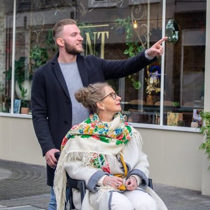 man walking with woman on wheelchair